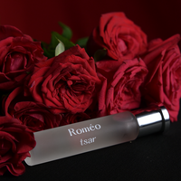 Roméo by Tsar 20 ml perfume bottle styled with red roses against a dark background