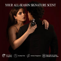 Female model holding Roméo by Tsar 100 ml perfume bottle while embracing a male model against a dark studio background
